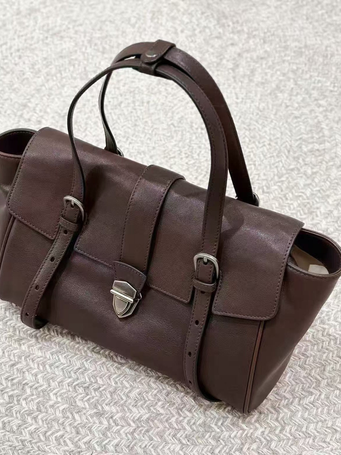 Coffee brown leather satchel showing its structured silhouette