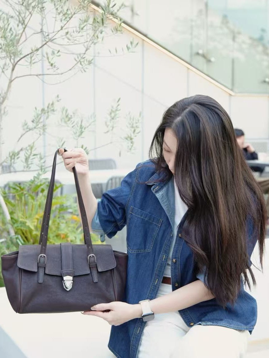 Woman carrying the coffee brown structured satchel with a denim look