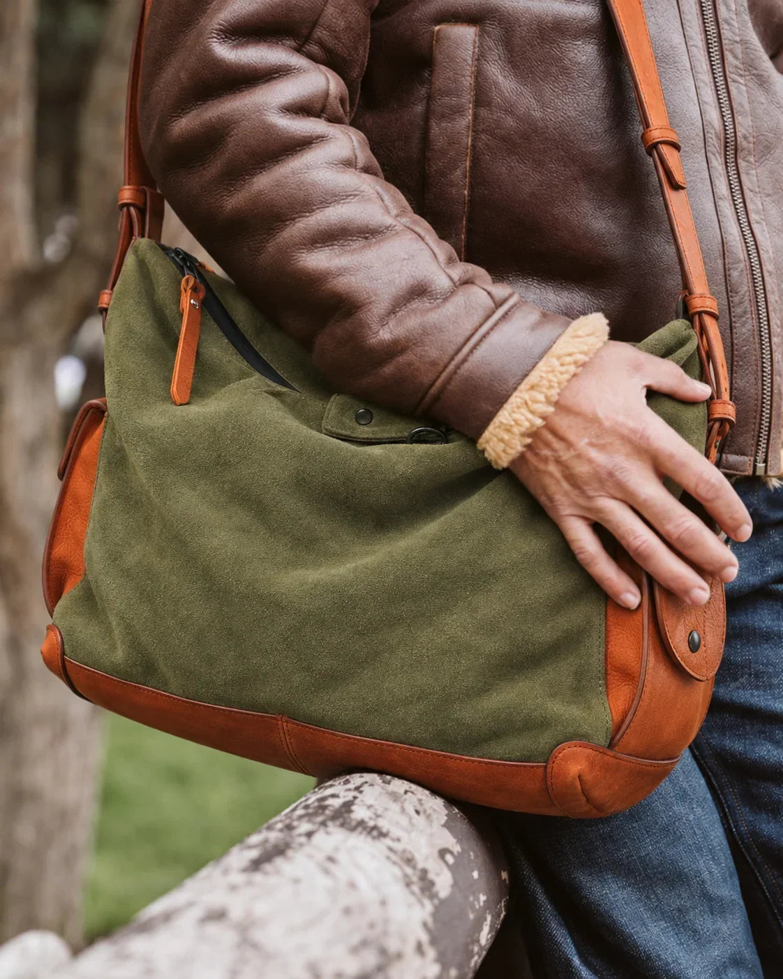 Olive leather crossbody bag worn with a brown jacket