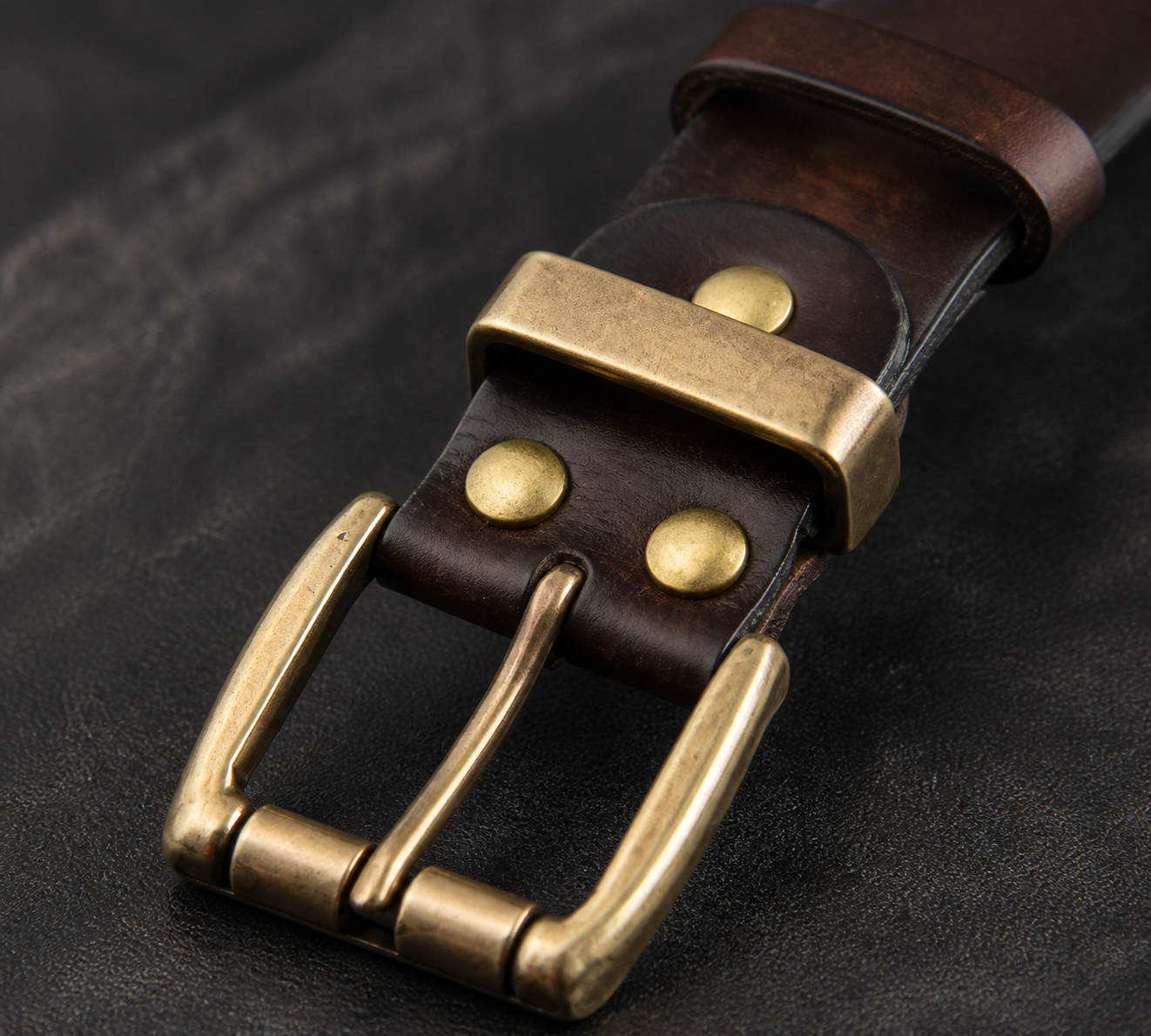 Close view of antique brass buckle and waxed leather grain