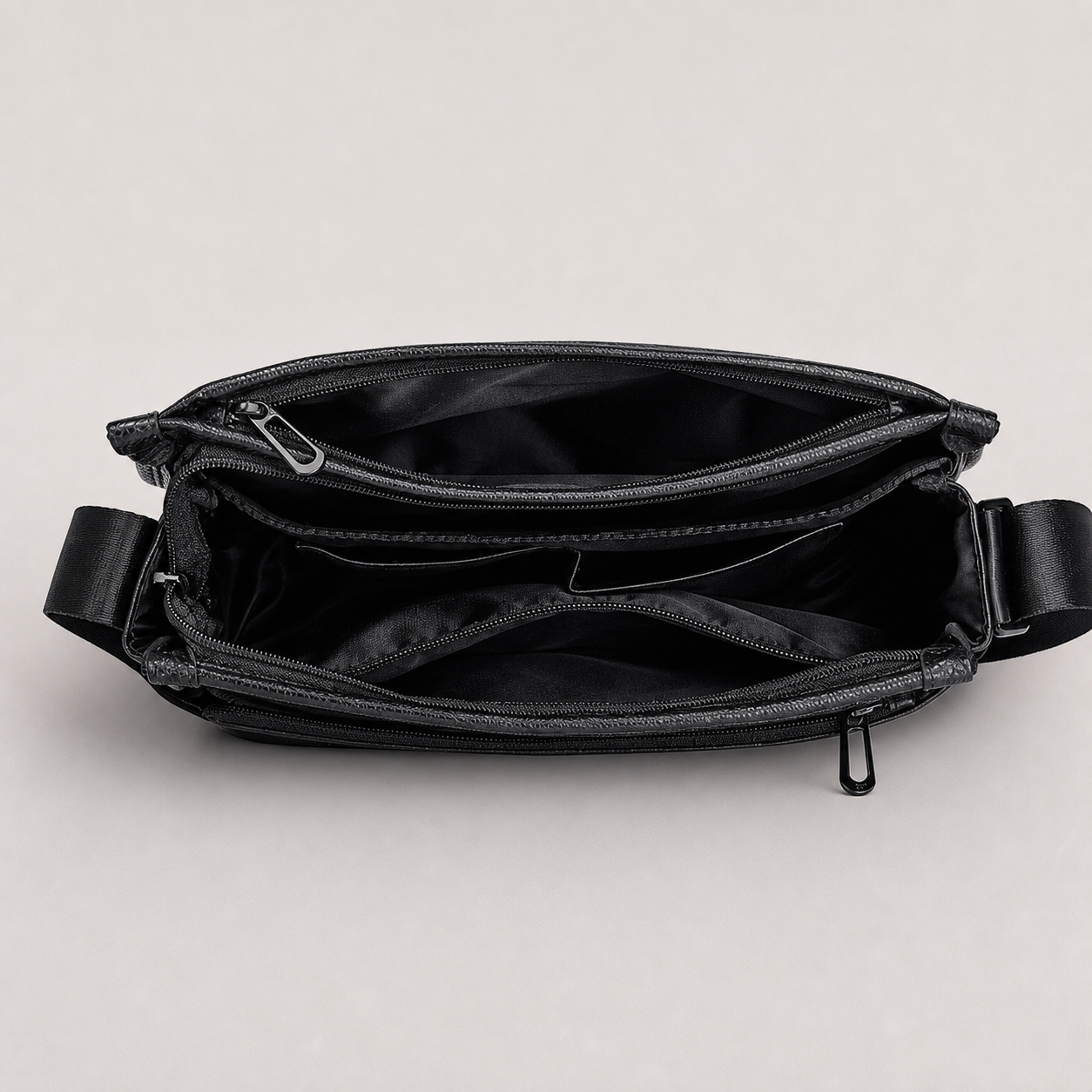 Open black leather messenger bag showing multiple organized compartments