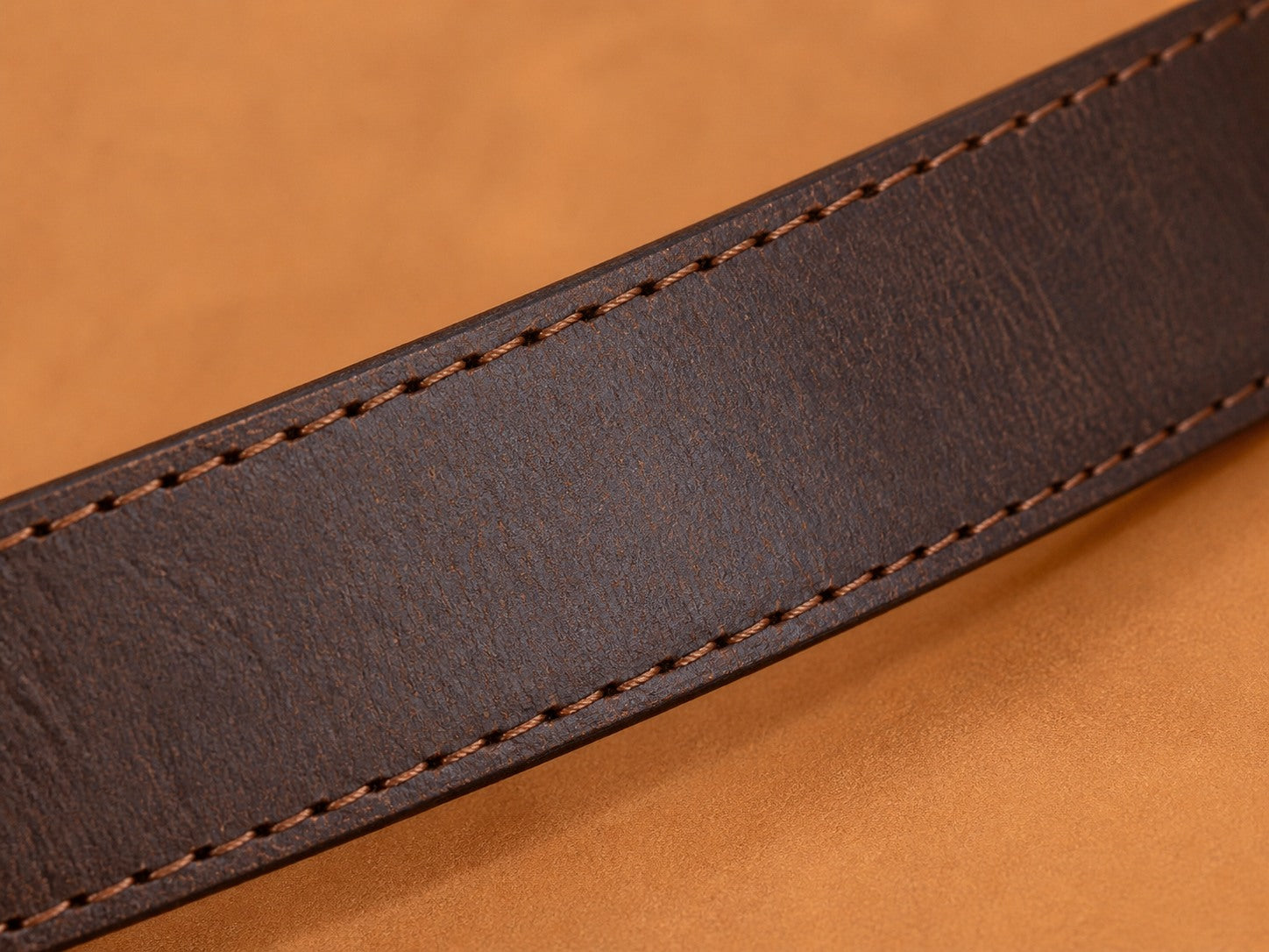 Close-up of Coffee brown full-grain leather and reinforced stitching